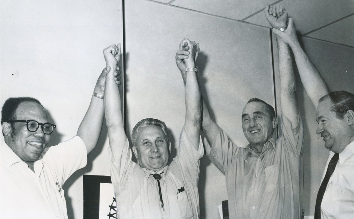 Charles Brooks and unnamed associates with their hands in the air celebrating